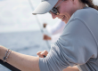 female angler wearing grey with fising pole