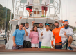 entire team of agitaor on back of boat laughing
